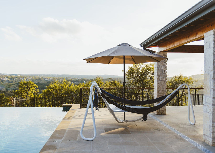 Kammok Stand Baya Cloud White on a pool deck overlooking the countryside.