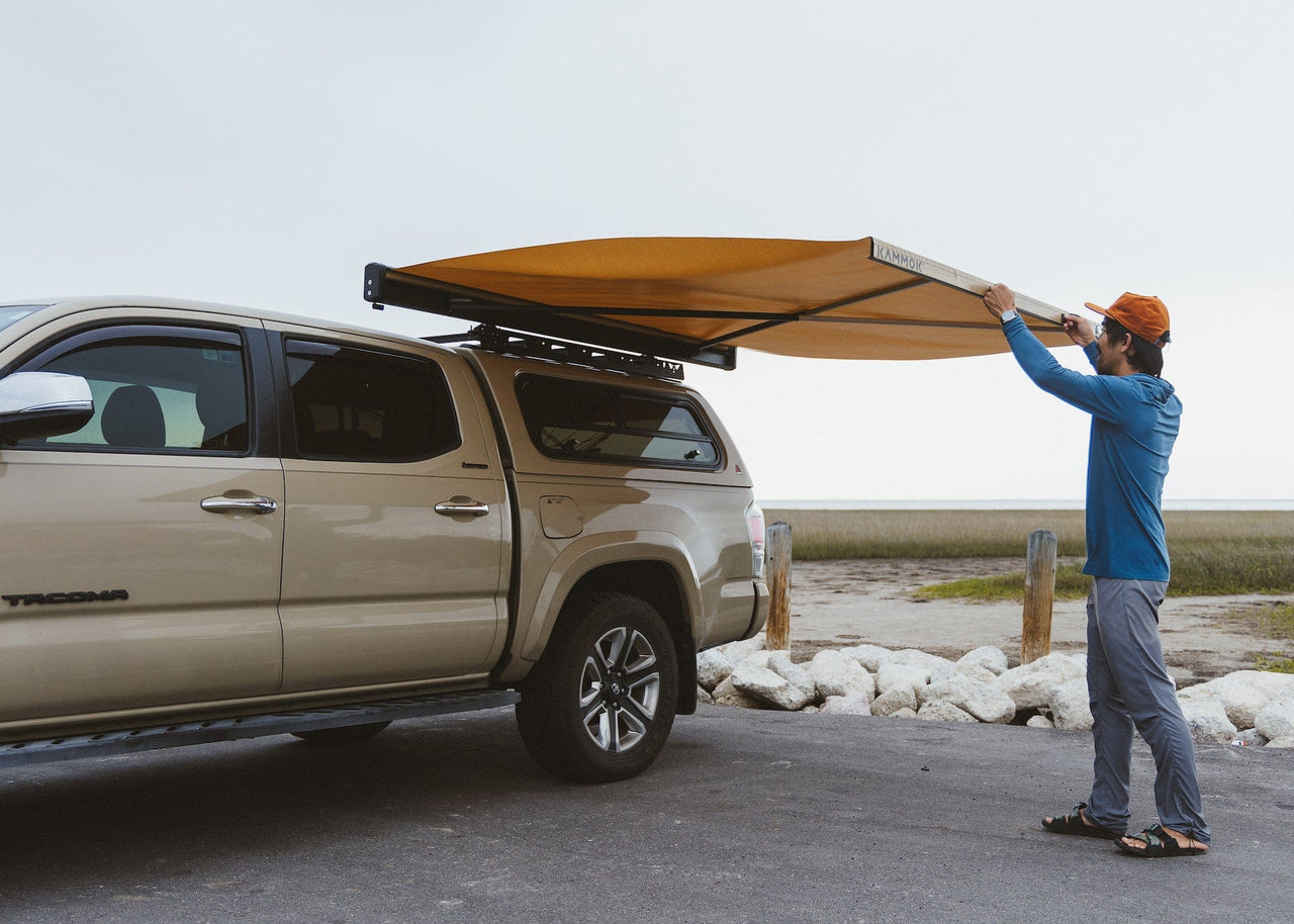 Man opening up a crosswing awning attached to his Toyota Tacoma. Shelter in just three seconds—Crosswing's lightning-fast deployment makes it the awning you'll actually use.