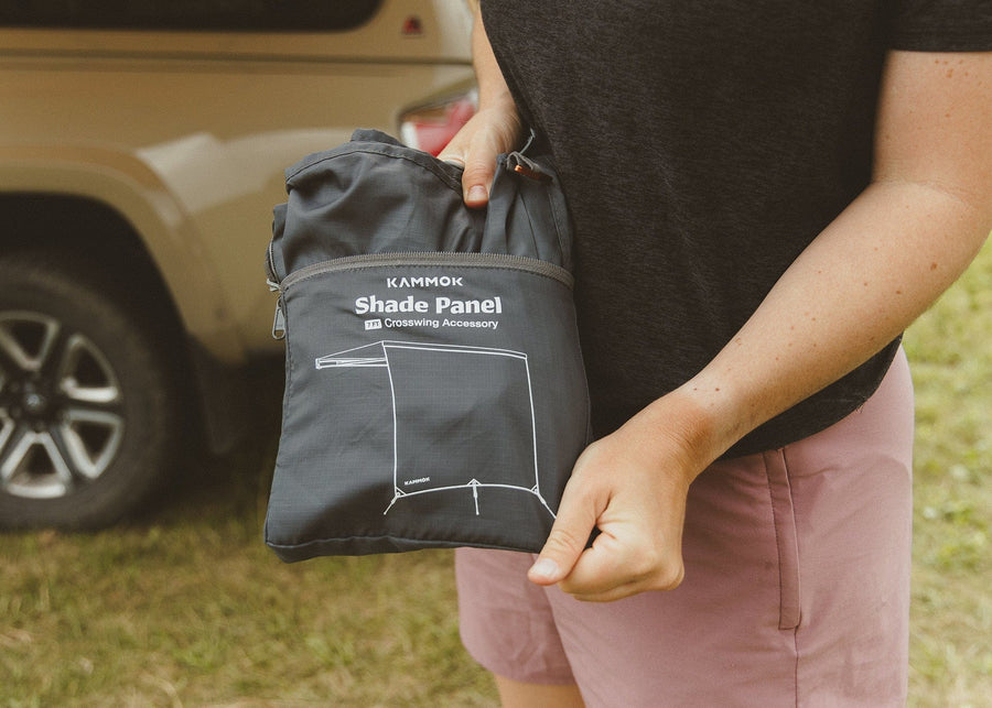 Man pulling a Kammok Crosswing Shade Panel out of the bag.