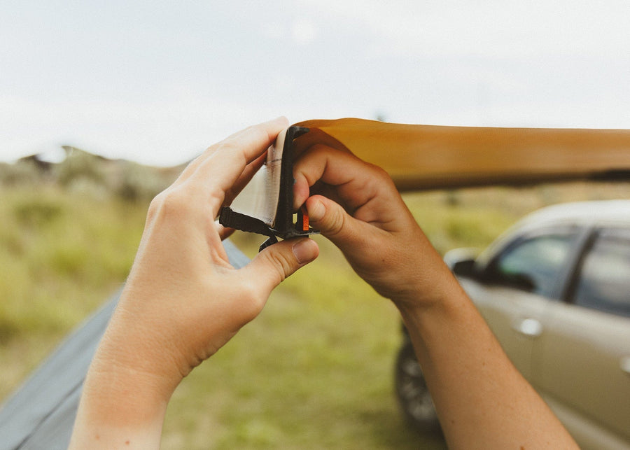 Close up of hands connecting a shade panel to the Kammok Crosswing.