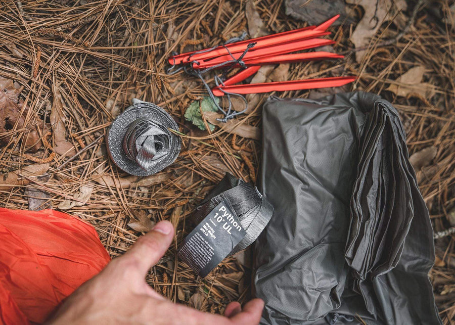 Close up of Kammok Hammock Mantis UL and python straps sitting on forest floor.