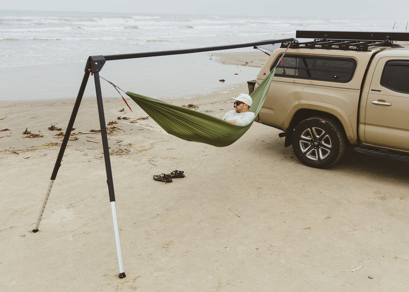 Man on beach in a Roo Hammock on a Kammok Stand Outpost