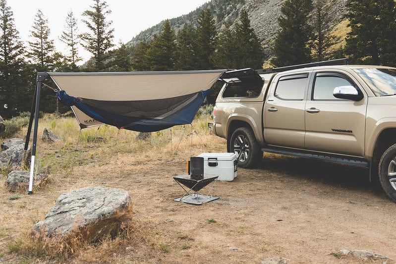 Kammok Hammock Tent Mantis installed on an outpost attached to a truck in the woods with mountains in background.