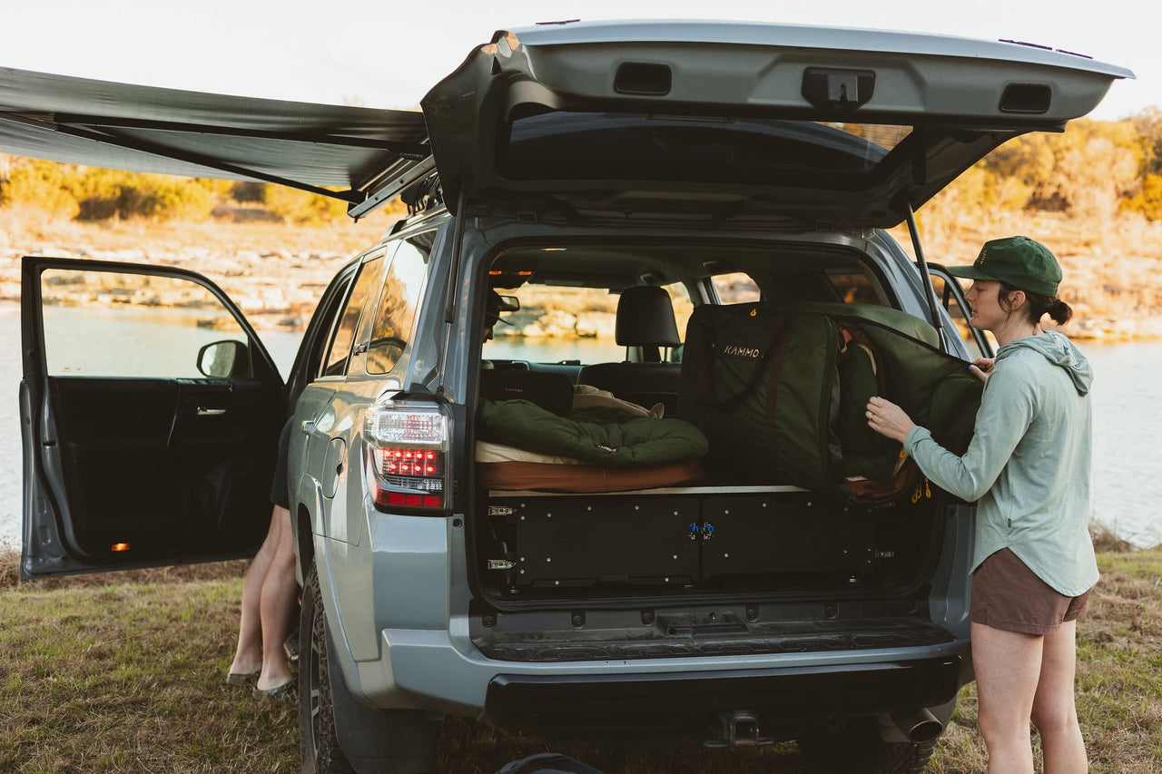 Woman unpacking the Kammok Ursa Sleep System from the back of the car.