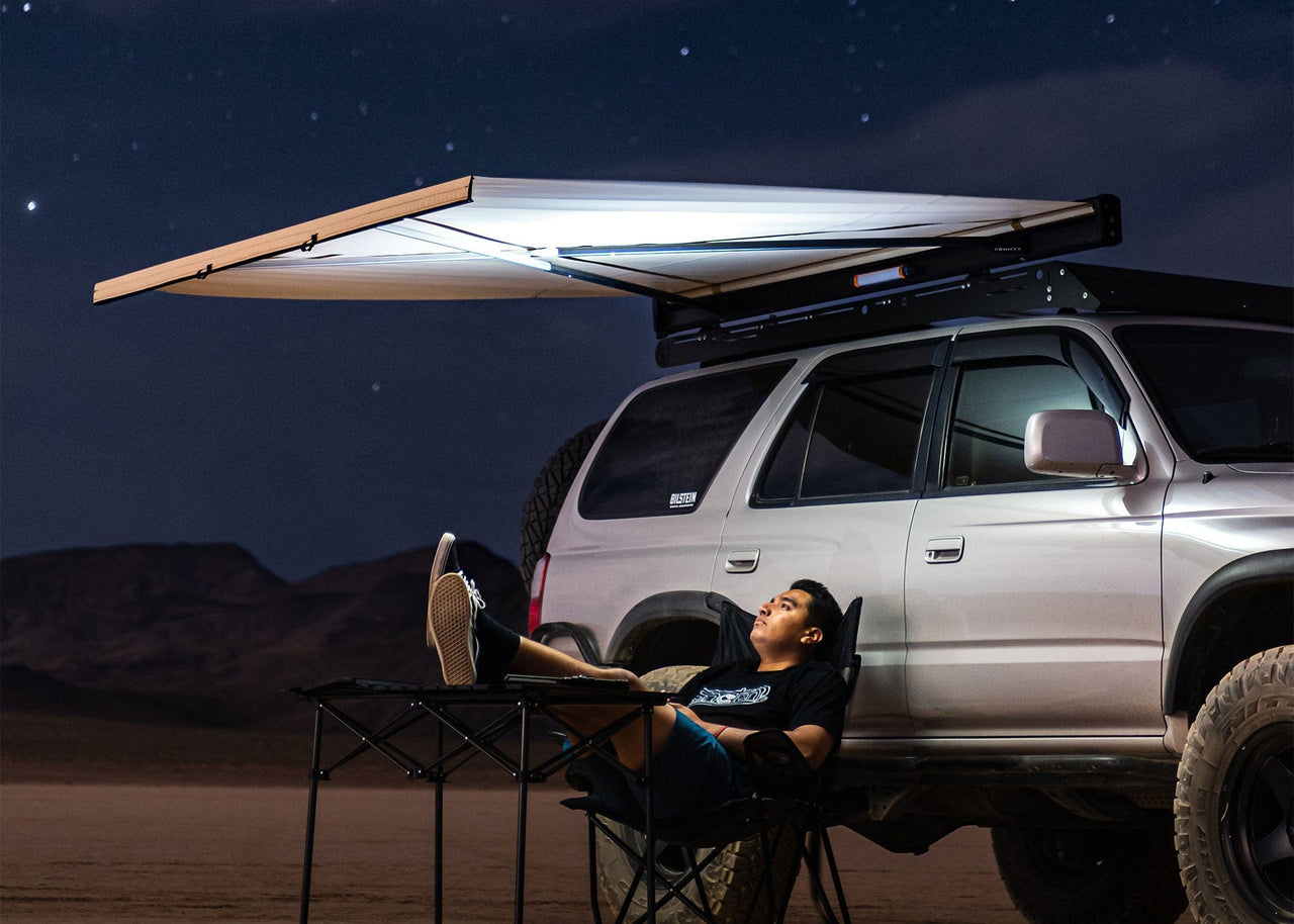 Man sitting underneath a lit Crosswing with Stars in the sky.