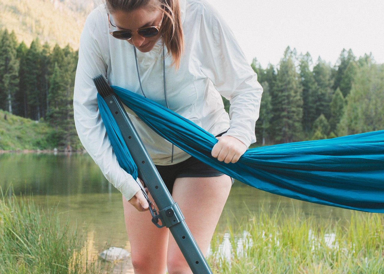 Woman attaching her Roo Double Hammock to her Swiftlet Hammock Stand.