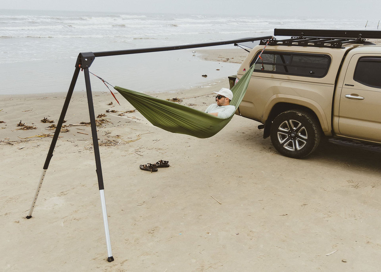 Man on beach in a Roo Hammock on a Kammok Stand Outpost