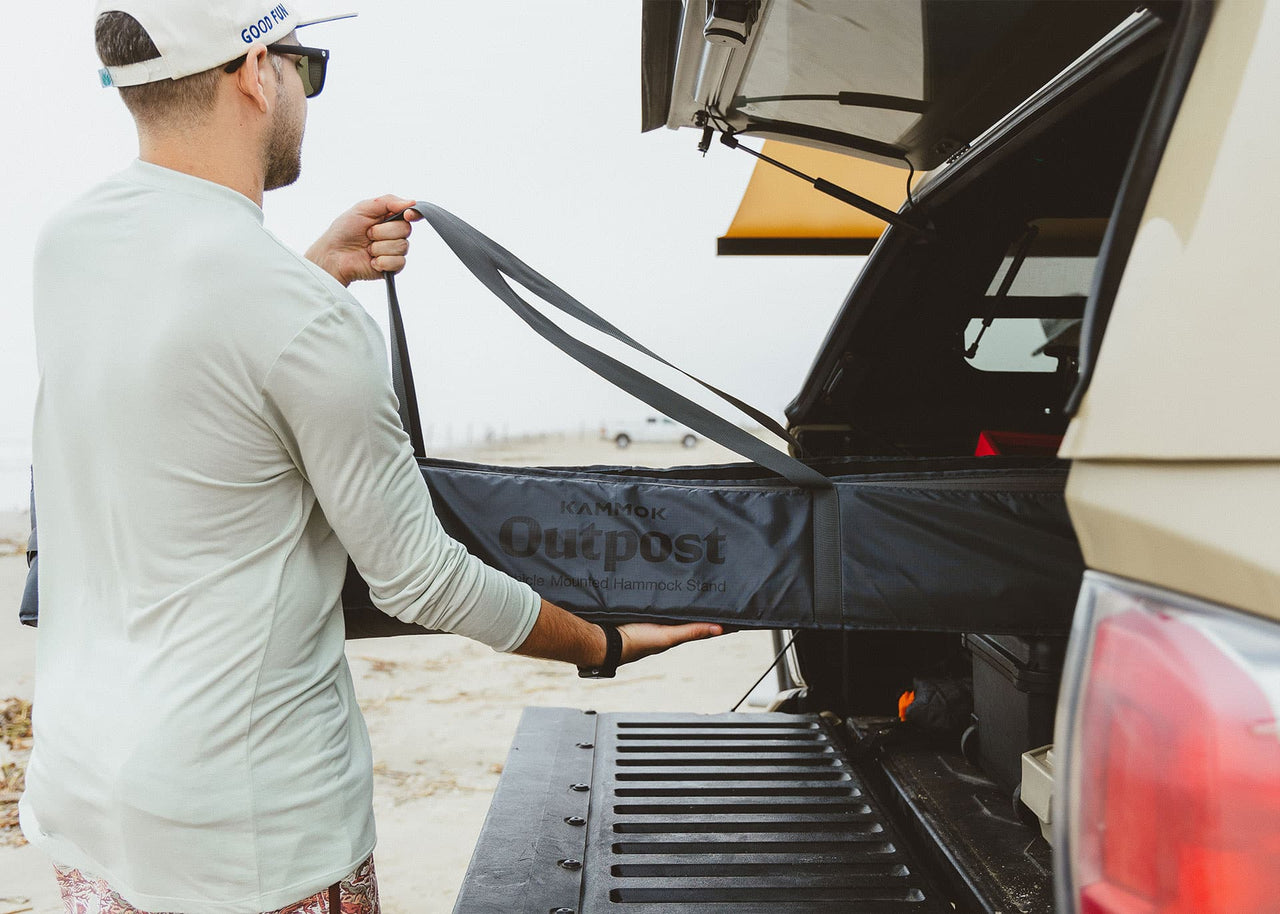 Man pulling a Kammok Stand Outpost in it's storage bag out o fthe back of his SUV.