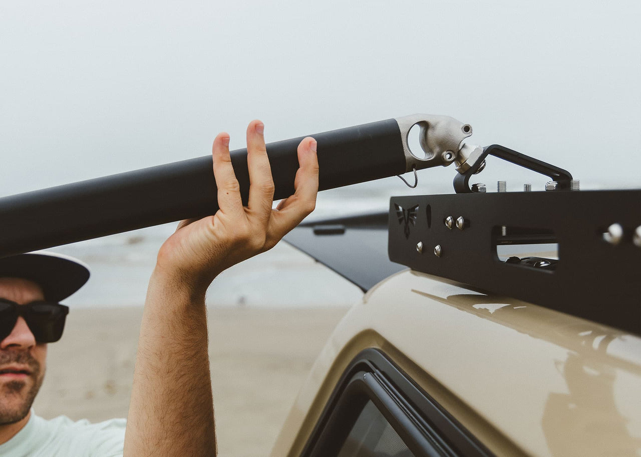 Close up of man on the beach installing his Kammok Stand Outpost