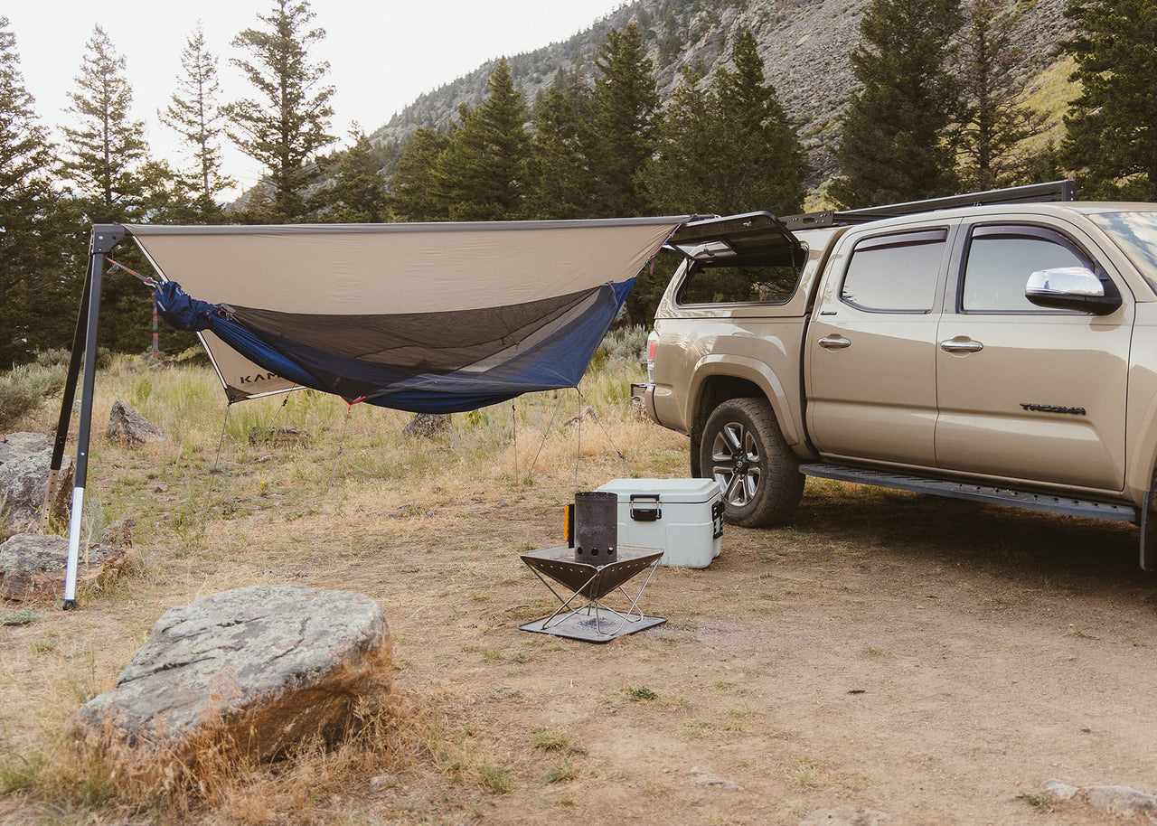 Installed Kammok Bundle Outpost Overland Bundle on Tacoma in Woods with Mountains in backdrop.