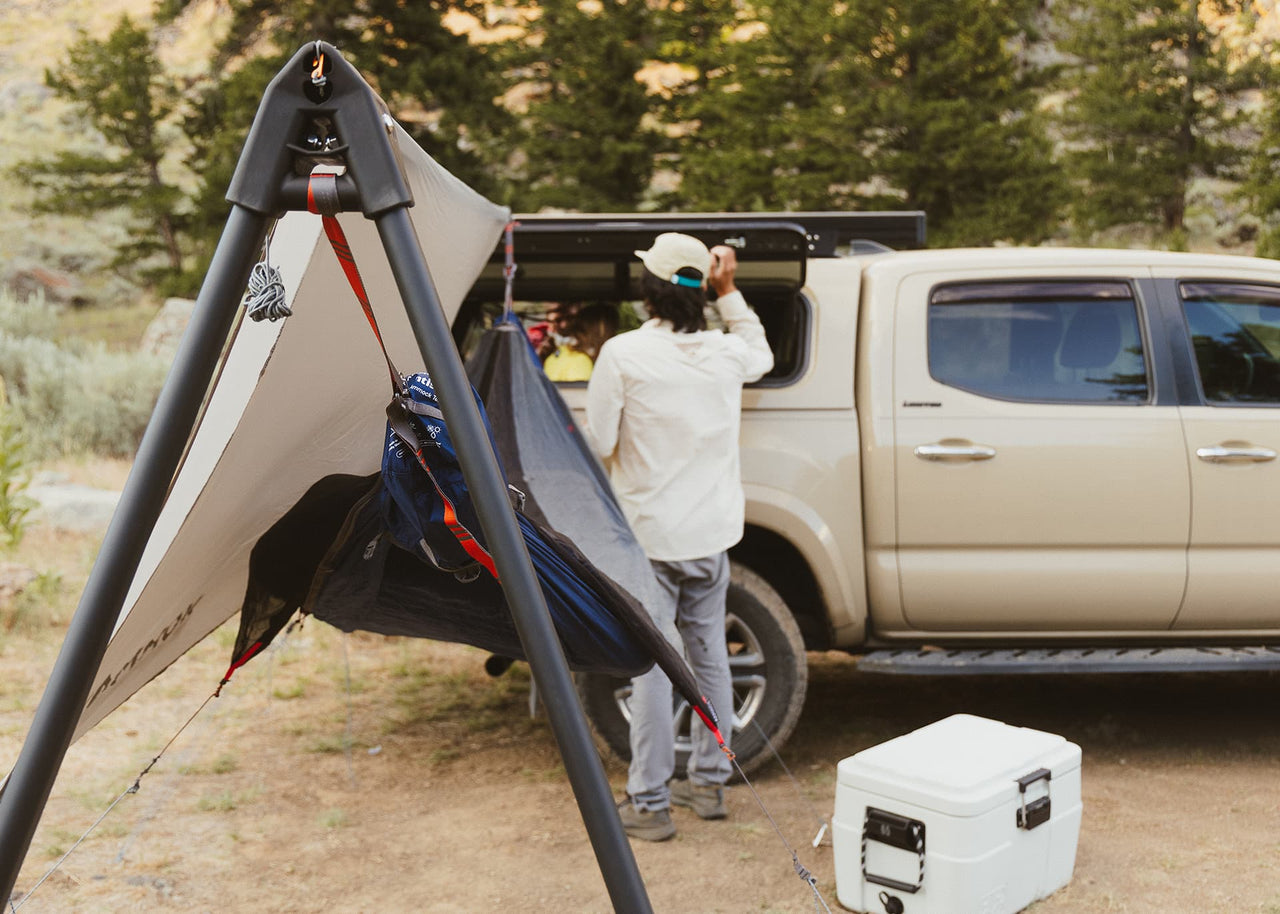 Man opening truck window with Kammok Bundle Outpost Overland Bundle installed behind him.