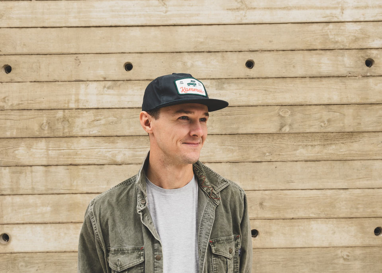 Man in front of wood wall wearing a Kammok Apparel Adventure Rope Hat