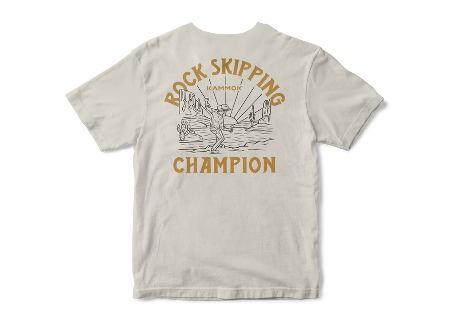 Back side of tshirt in white with a graphic of a cowboy skipping a rock with the phrase Rock Skipping Champion.
