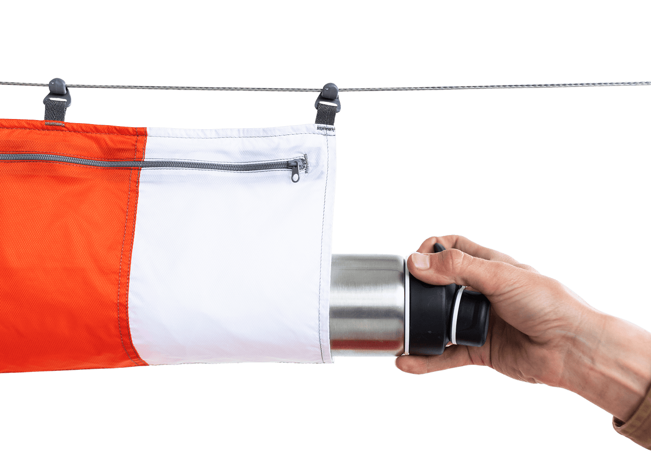 Studio Image of a hand silding a water bottle out of a Kammok Storage Ridge