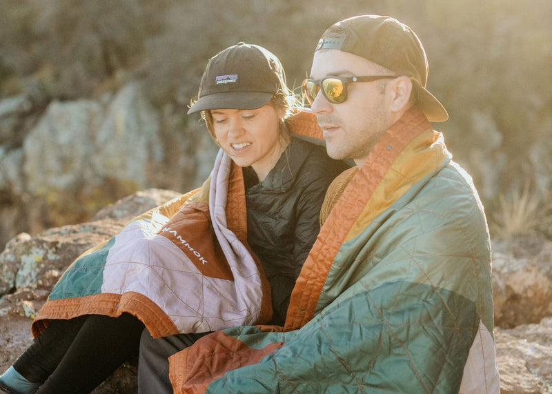 Couple Sitting wrapped in a Kammok Blanket Field Blanket Printed