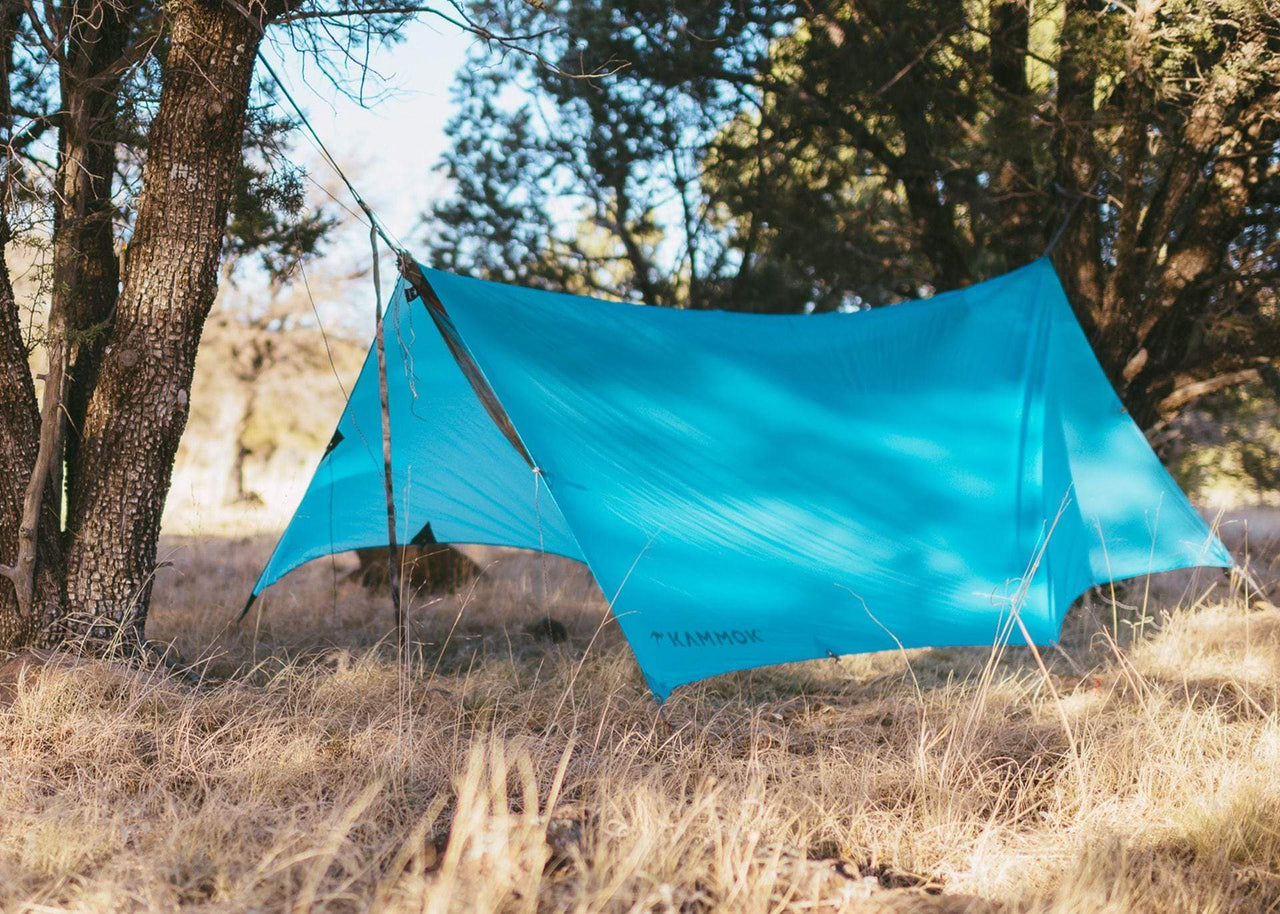 Kammok Weather Shelter Kuhli hanging in woods.