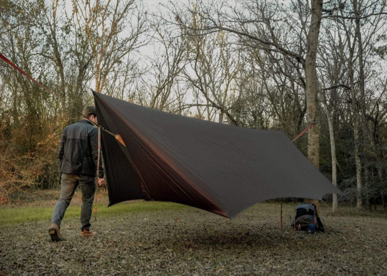 Kuhli Pro Hangig with Man walking behind it in woods.