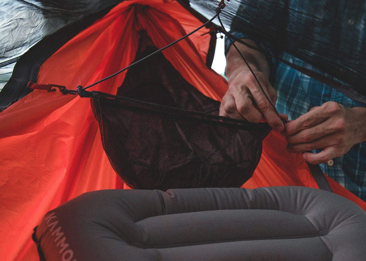 Close up of man's hands installing a Kammok Mantis Gear Loft