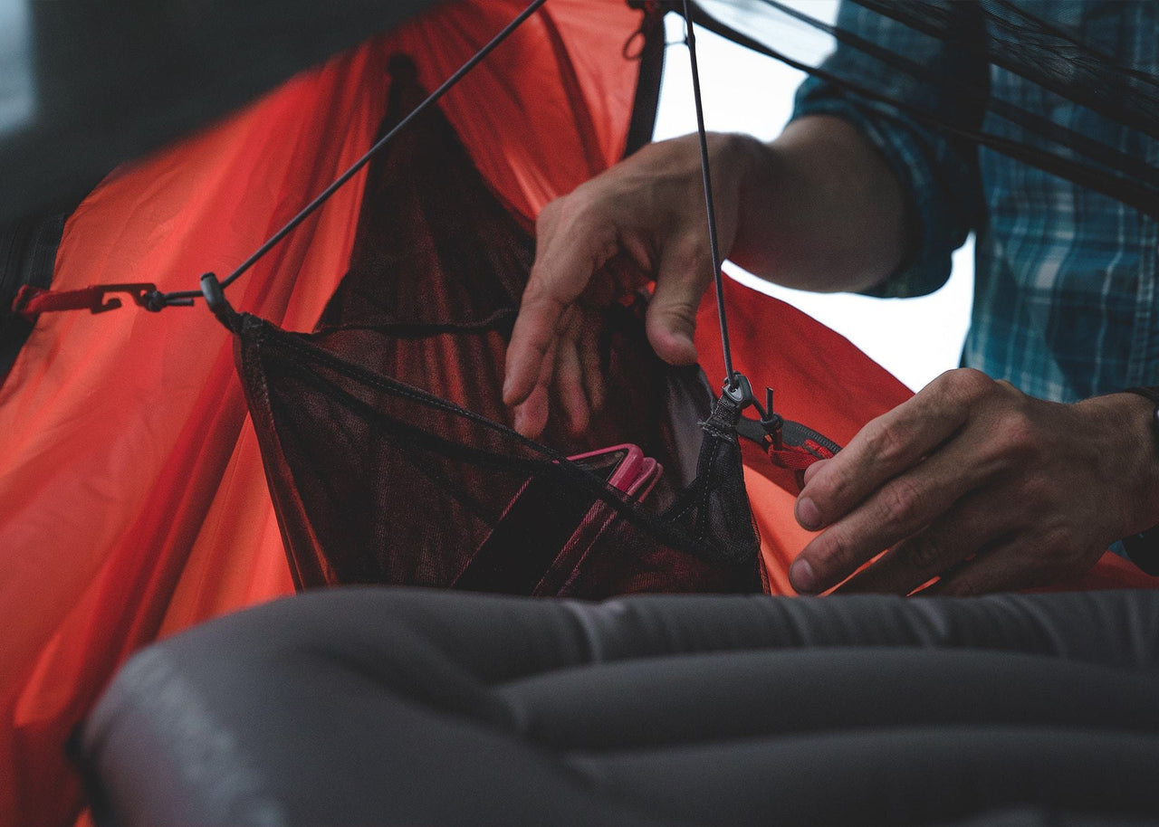 Man's hands reaching into a Mantis Gear Loft to grab phone.