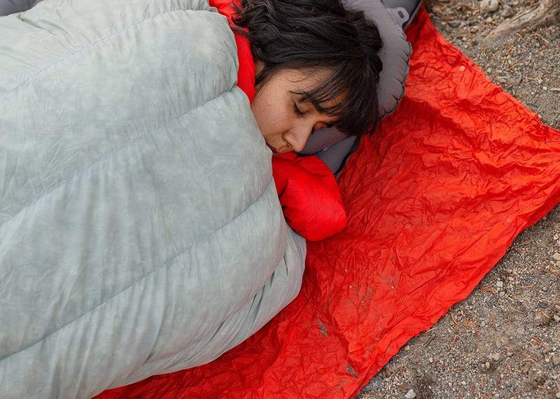 Women sleeping on a pongo pad with a Kammok Blanket Mesa Mat underneath.