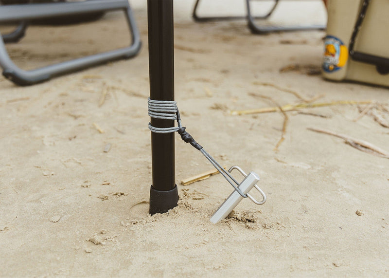 Close up of a Kammok Pole Pack staked into sand on beach.