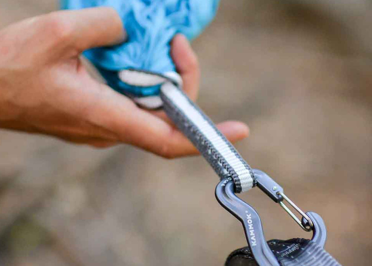 Close up of hands holding racer sling attached to hammock.