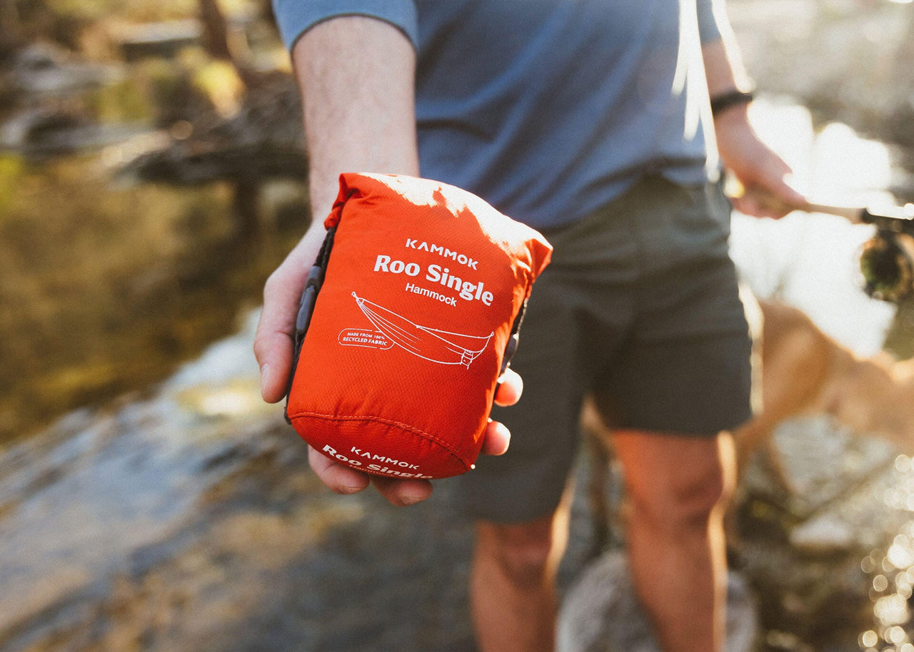 Kammok Hammock Roo Single in its storage bag in the palm of a man's hand.