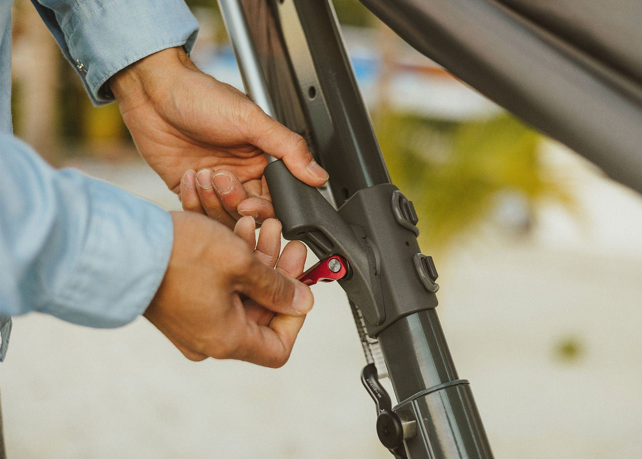 Closeup of man attaching Swiftlet Shade Poles to Kammok Swiftlet portable hammock stand.