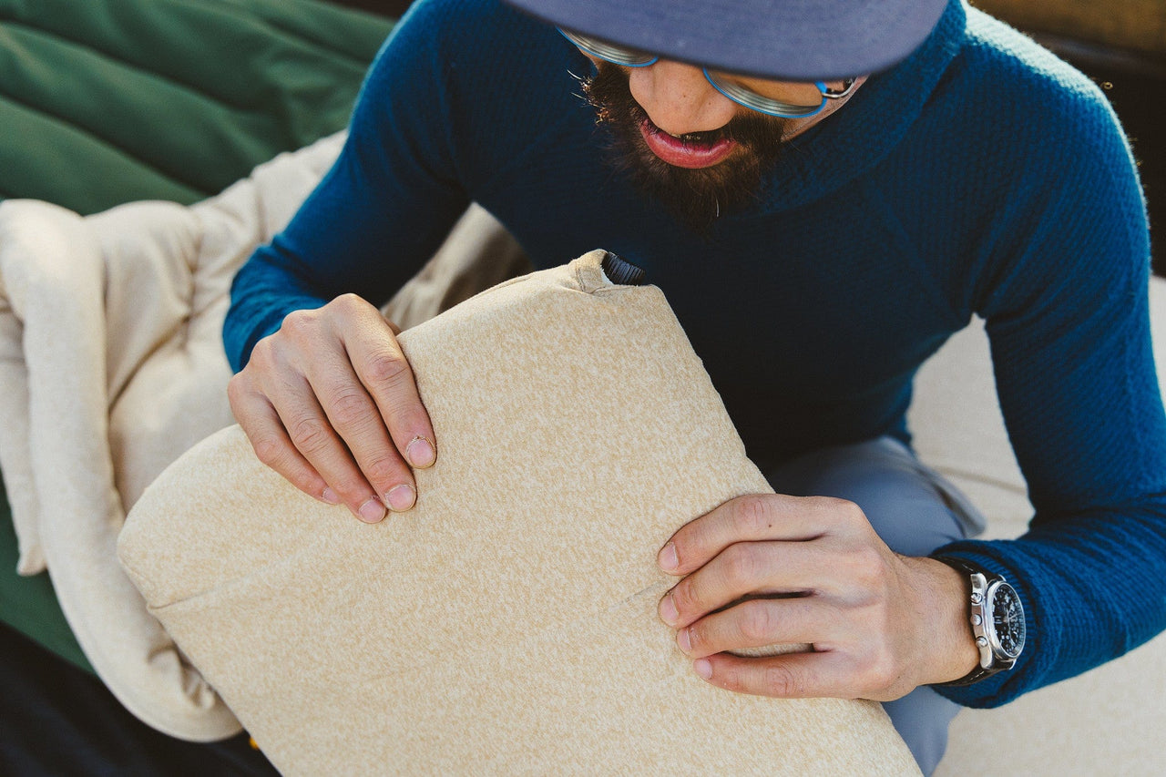 Man inflating Kammok Ursa Pillow