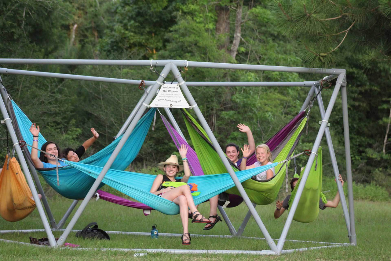 Summer camp with campers hanging on hammocks.